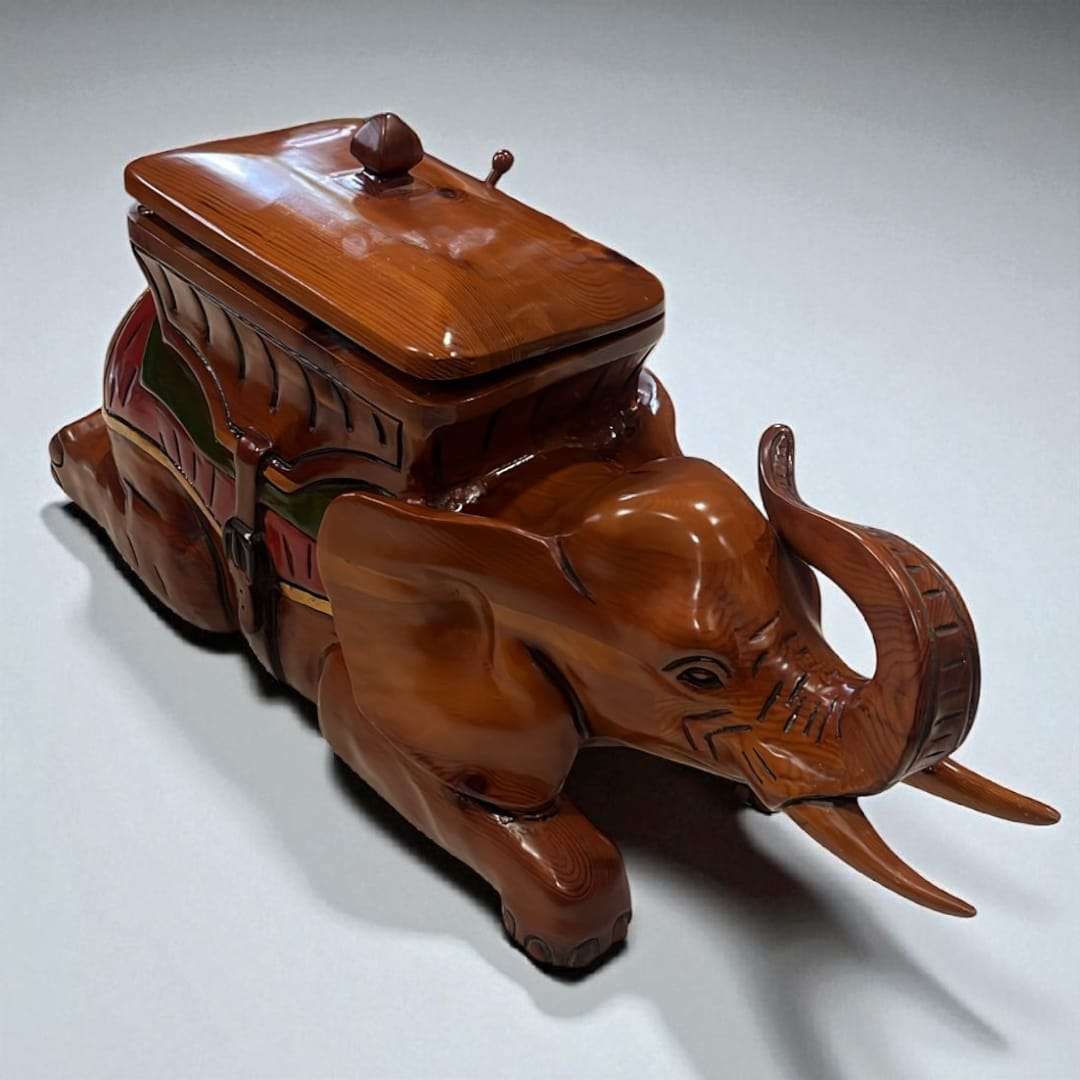 Baúl elefante tallado en madera visto desde arriba con tapa cerrada.