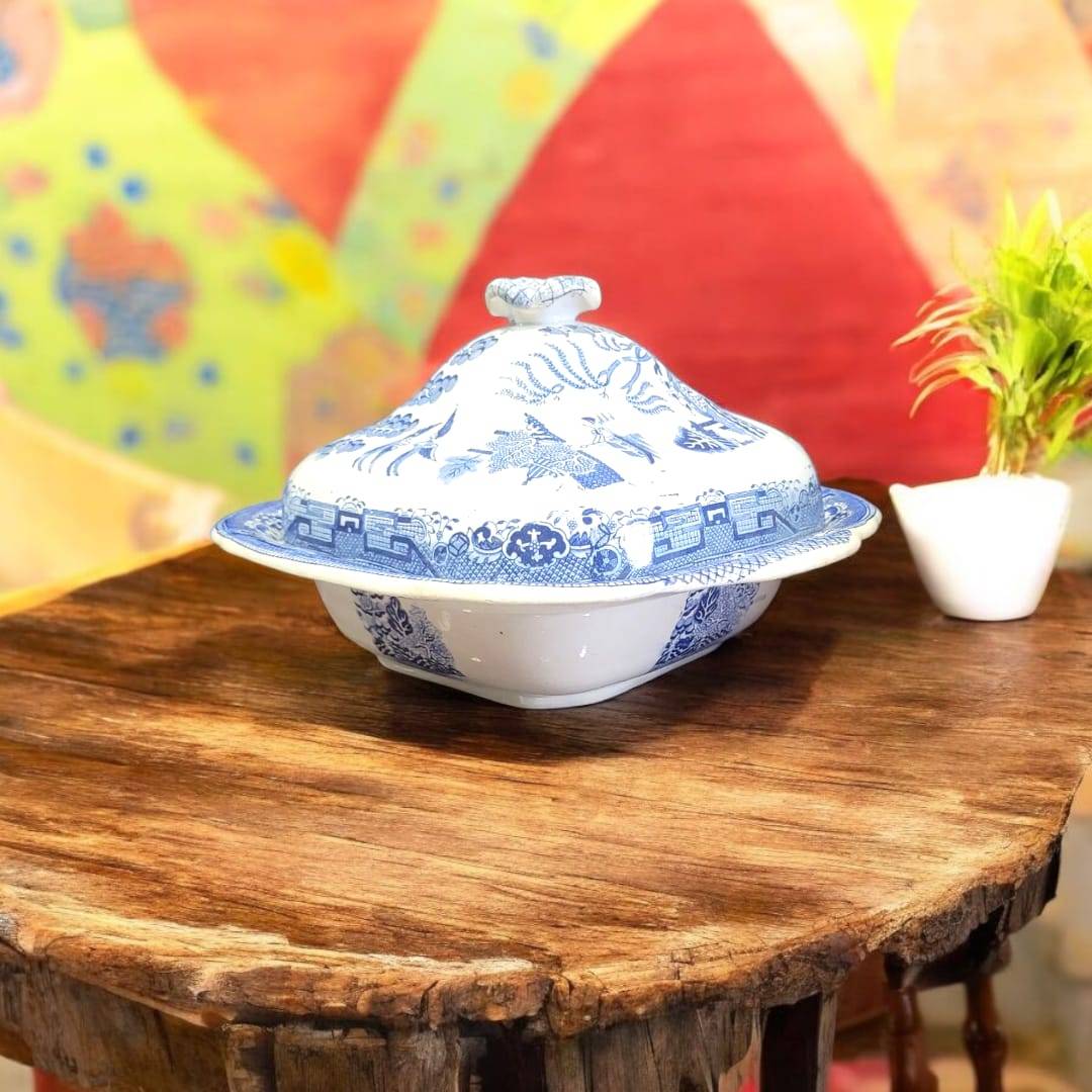 Fuente antigua Willow con tapa de porcelana inglesa original, diseño azul chinesco sobre mesa rústica. Ideal para decoración vintage de hogar.