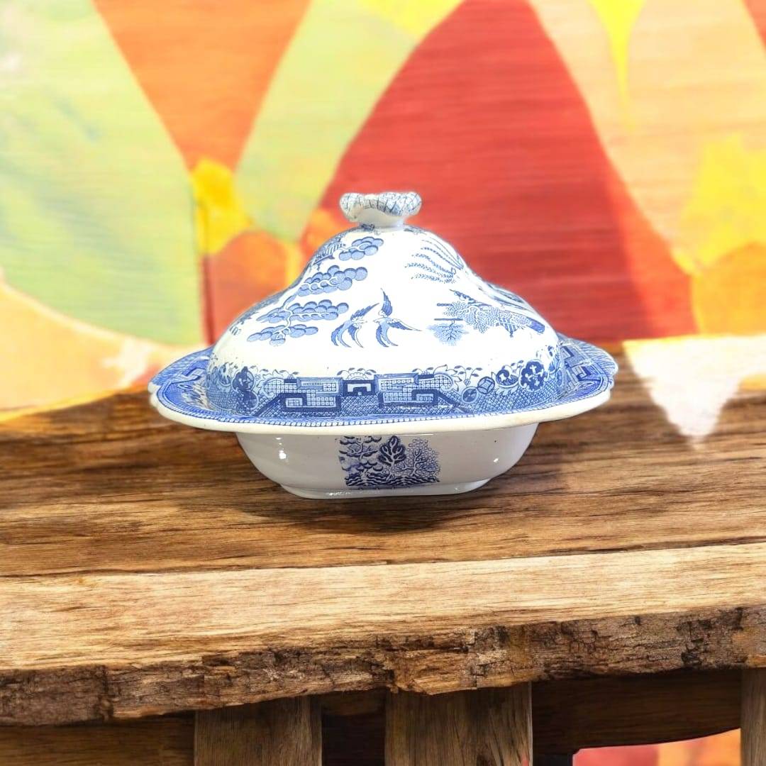 Fuente antigua Willow con tapa de porcelana inglesa original, diseño azul chinesco sobre mesa rústica. Ideal para decoración vintage de hogar.