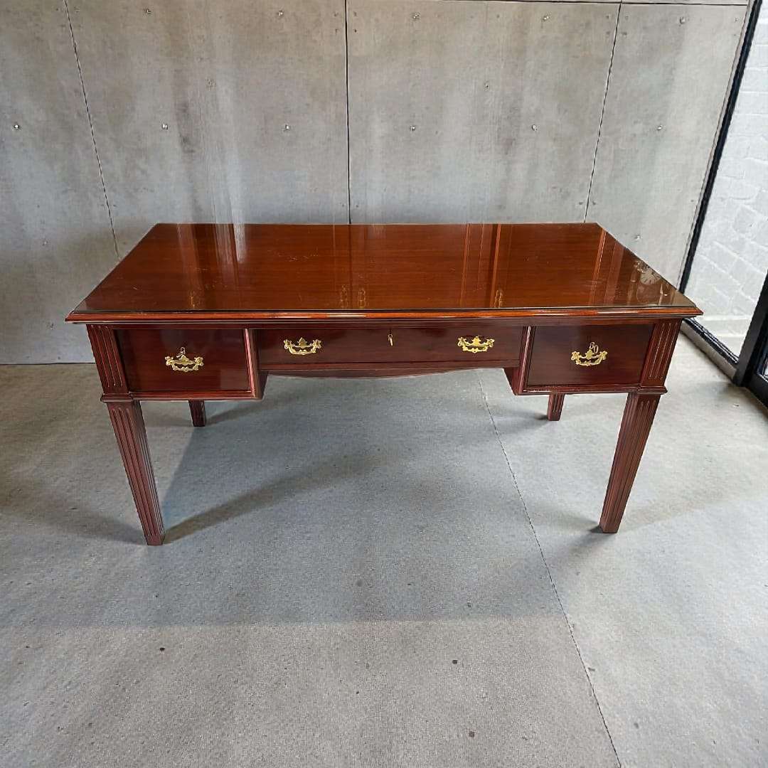 Escritorio de caoba con tapa de cristal vista frontal.