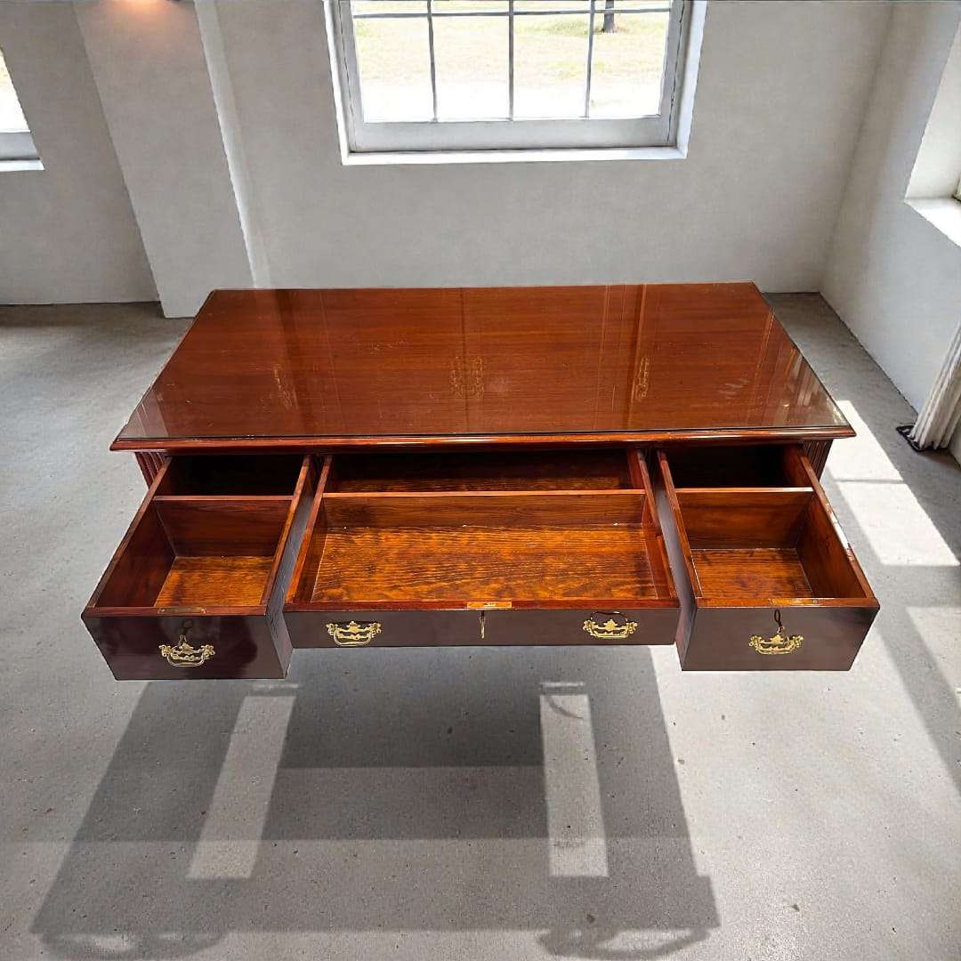 Escritorio de caoba con tapa de cristal vista frontal.