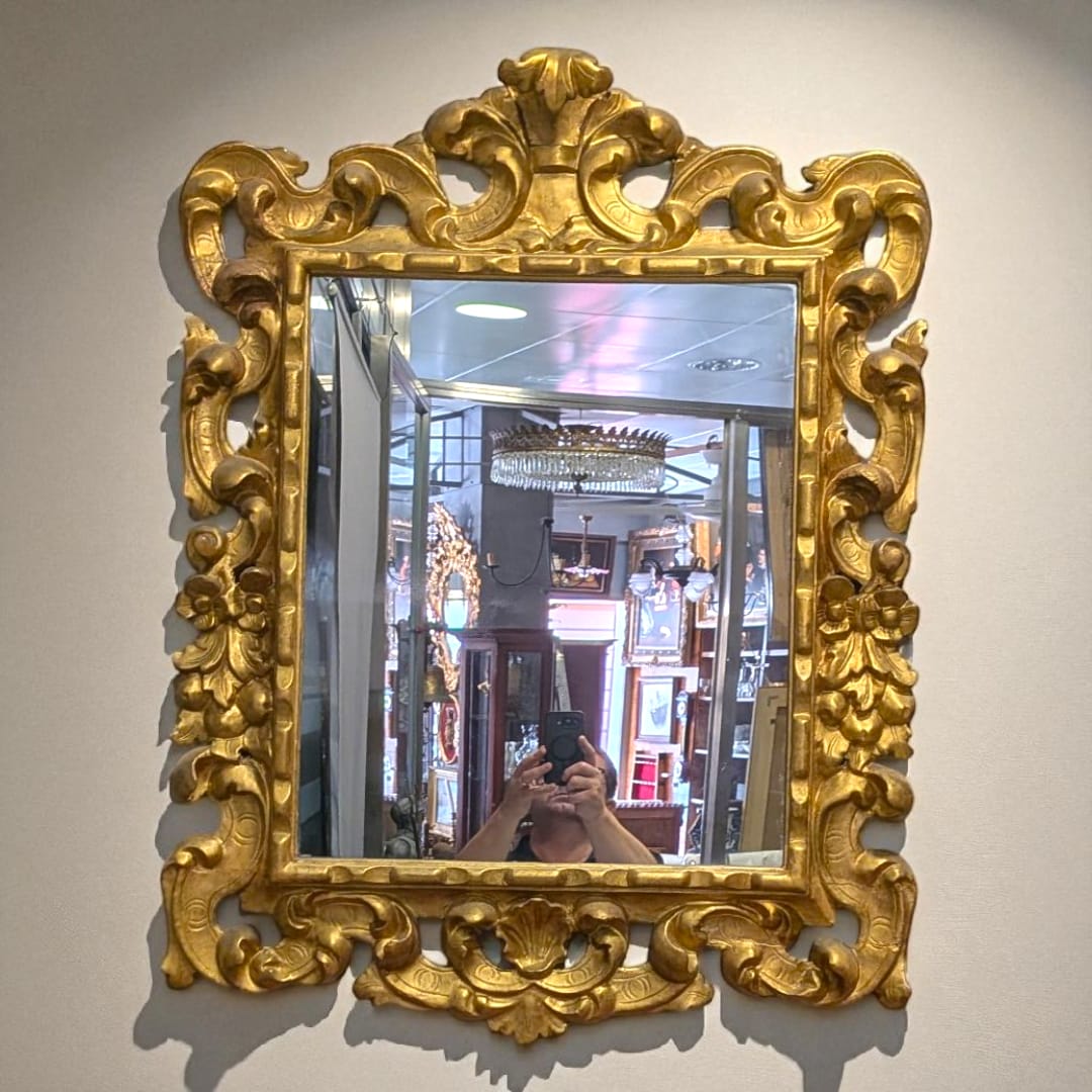 Espejo dorado isabelino del siglo XIX con talla en madera, marco ornamentado con penacho decorativo ideal para decoración clásica de interiores.