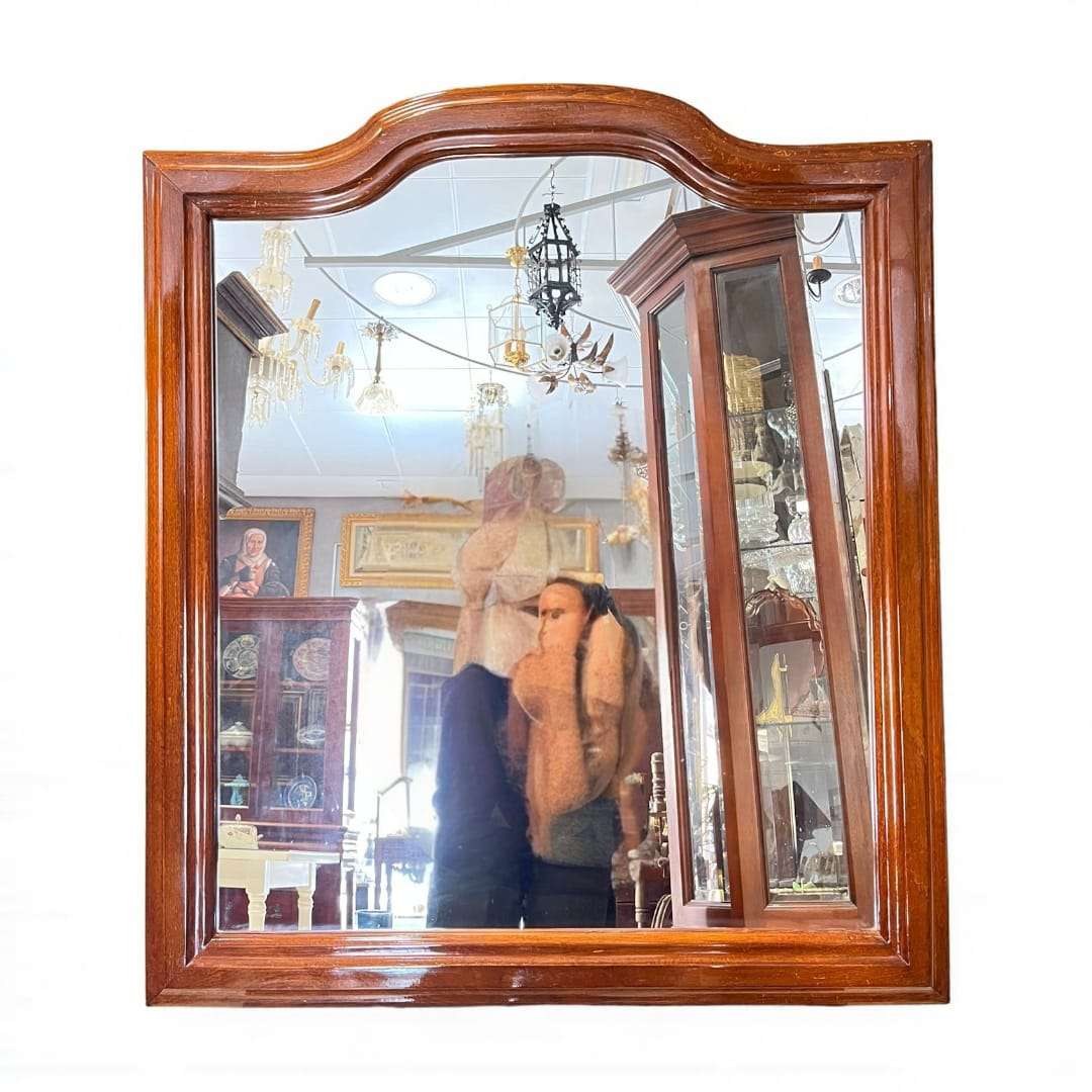 Espejo de madera con marco clásico visto de frente.