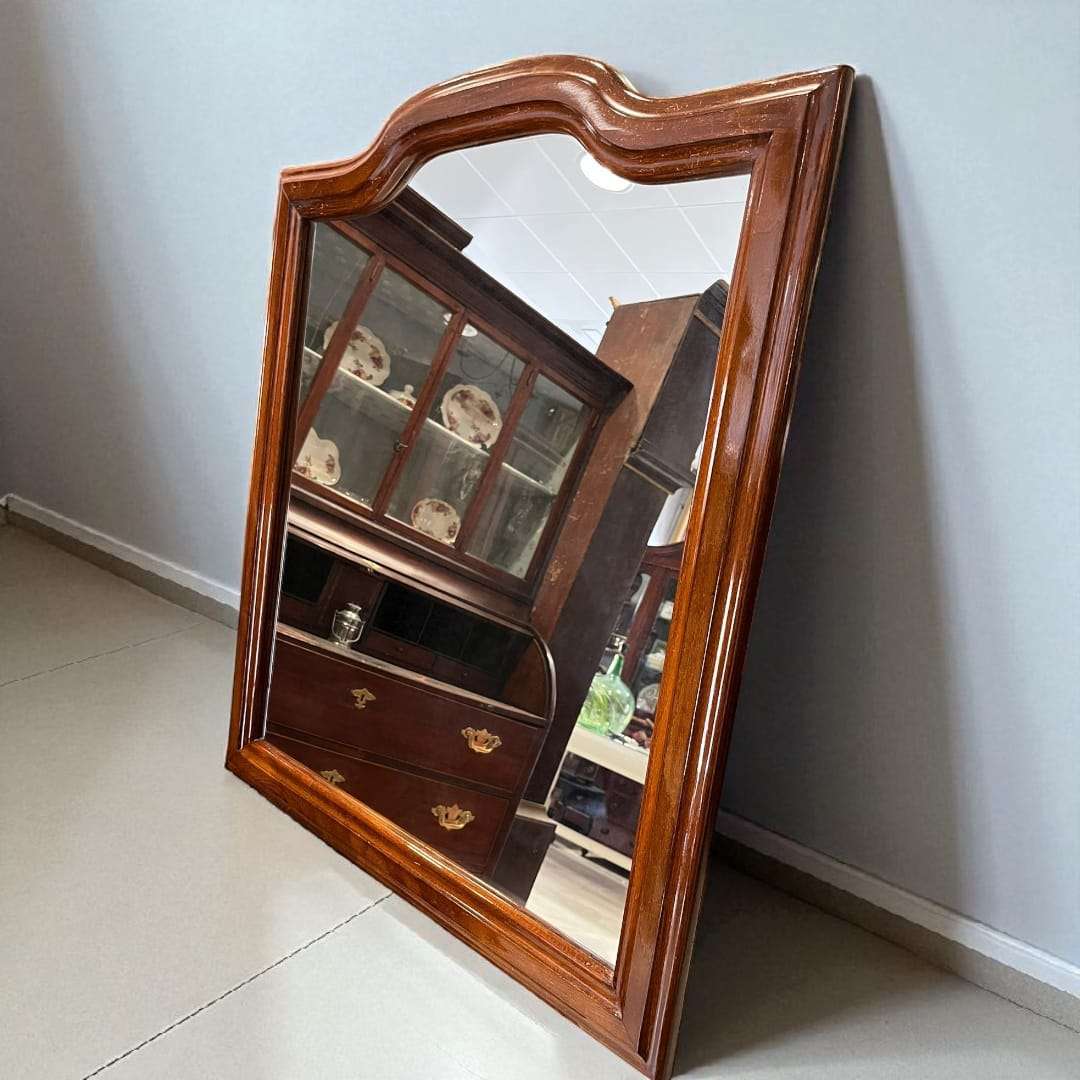 Espejo de madera con marco clásico visto de frente.