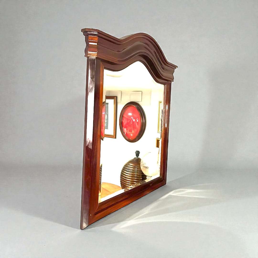 Espejo de caoba con cristal biselado clásico antiguo y copete curvo, ideal para decoración elegante en salones o espacios vintage.