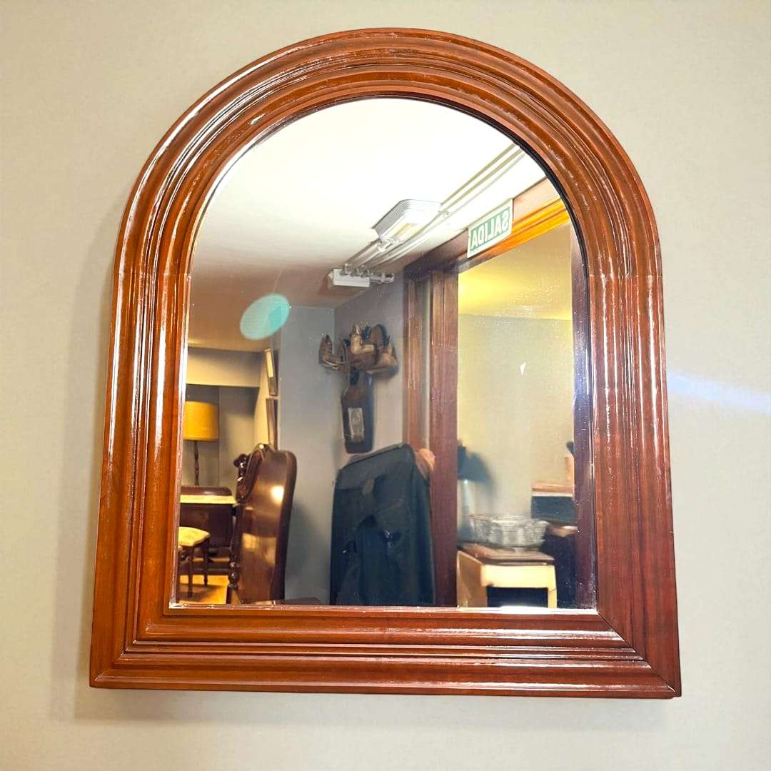 Espejo de caoba semi ovalado con marco sencillo y elegante.