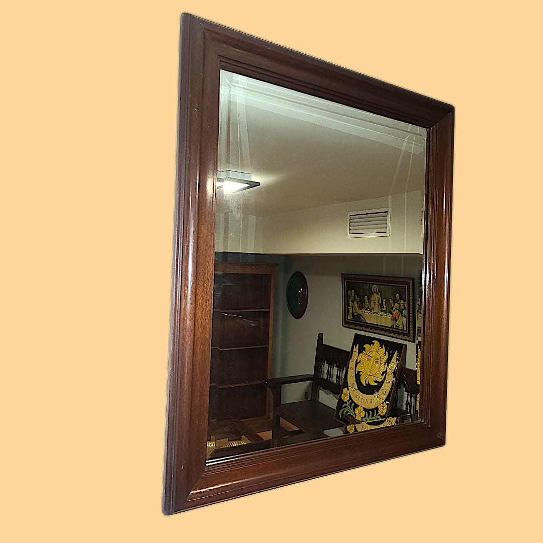 Imagen del espejo colgado en un salón, aportando amplitud y luminosidad al espacio.

