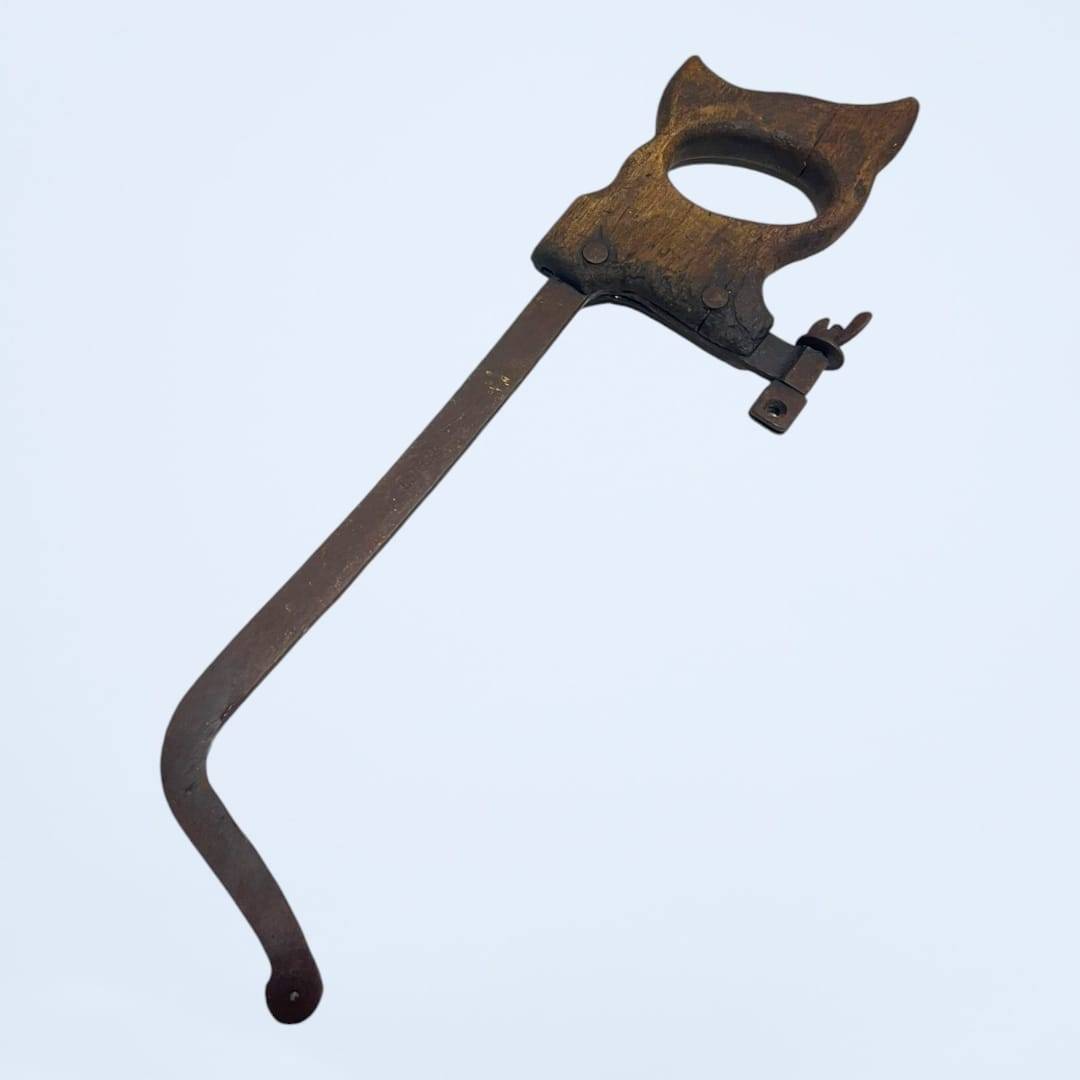 Antigua sierra sin hoja con mango de madera desgastado, ideal para restauración y decoración vintage en talleres o espacios rústicos.