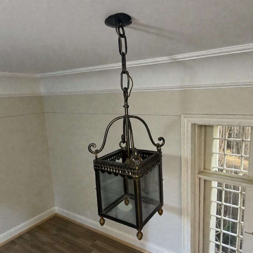  La parte inferior está compuesta por un cuerpo cuadrado de cristal transparente enmarcado por perfiles de bronce y rematado con pequeños pies decorativos, l