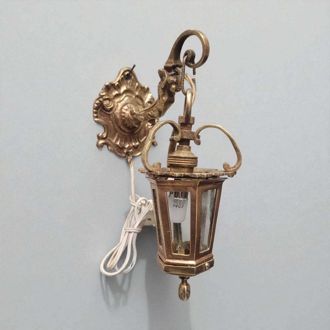 Farolillo de bronce antiguo para pared decorativa funcional con cable enrollado, ideal para decoración de interiores estilo vintage.