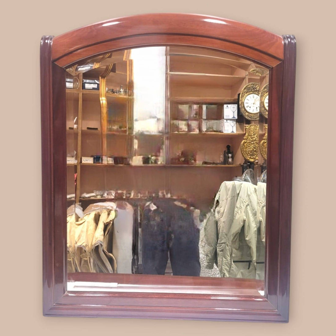 Espejo de caoba con cristal biselado y marco arqueado, ideal para decoración clásica en interiores elegantes. Calidad artesanal en cada detalle.