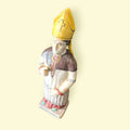 Vista en ángulo de figura de San Bernardo de Claraval en cerámica esmaltada, pieza devocional artesanal para decoración de interiores.