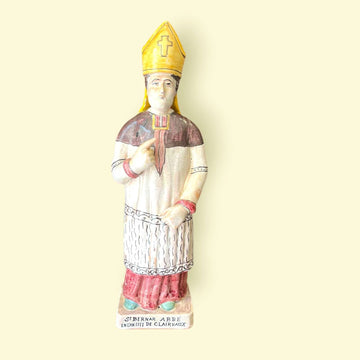 Figura de terracota San Bernardo de Claraval esmaltada con mitra amarilla y túnica decorada, ideal para decoración religiosa en el hogar.