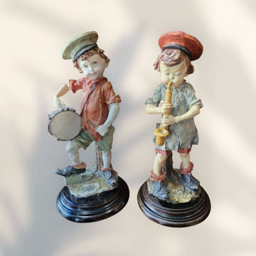 Figuras Italianas Armani - Figuras Musicales de niños músicos tocando tambor y saxofón en resina sobre base de madera, estilo Capodimonte.