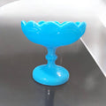 Frutero de opalina azul con diseño elegante y forma elevada. Ideal para decoración de hogar en estilo vintage o clásico.
