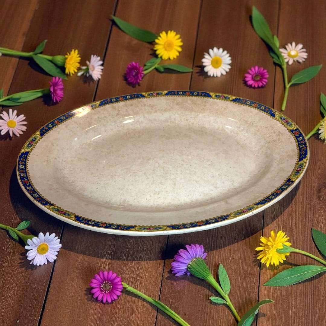 Fuente antigua con decoración floral Pickman rodeada de flores.