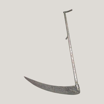 Guadaña antigua decorativa de hierro forjado tradicional con hoja curva y mango largo, ideal para decoración rústica en hogar o jardín.