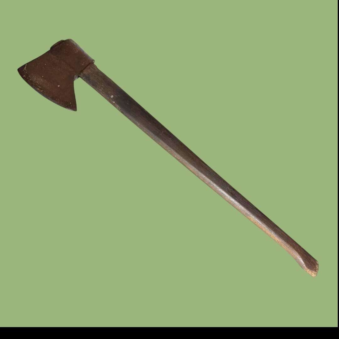 Hacha antigua de hierro forjado con mango de madera vista lateral.
