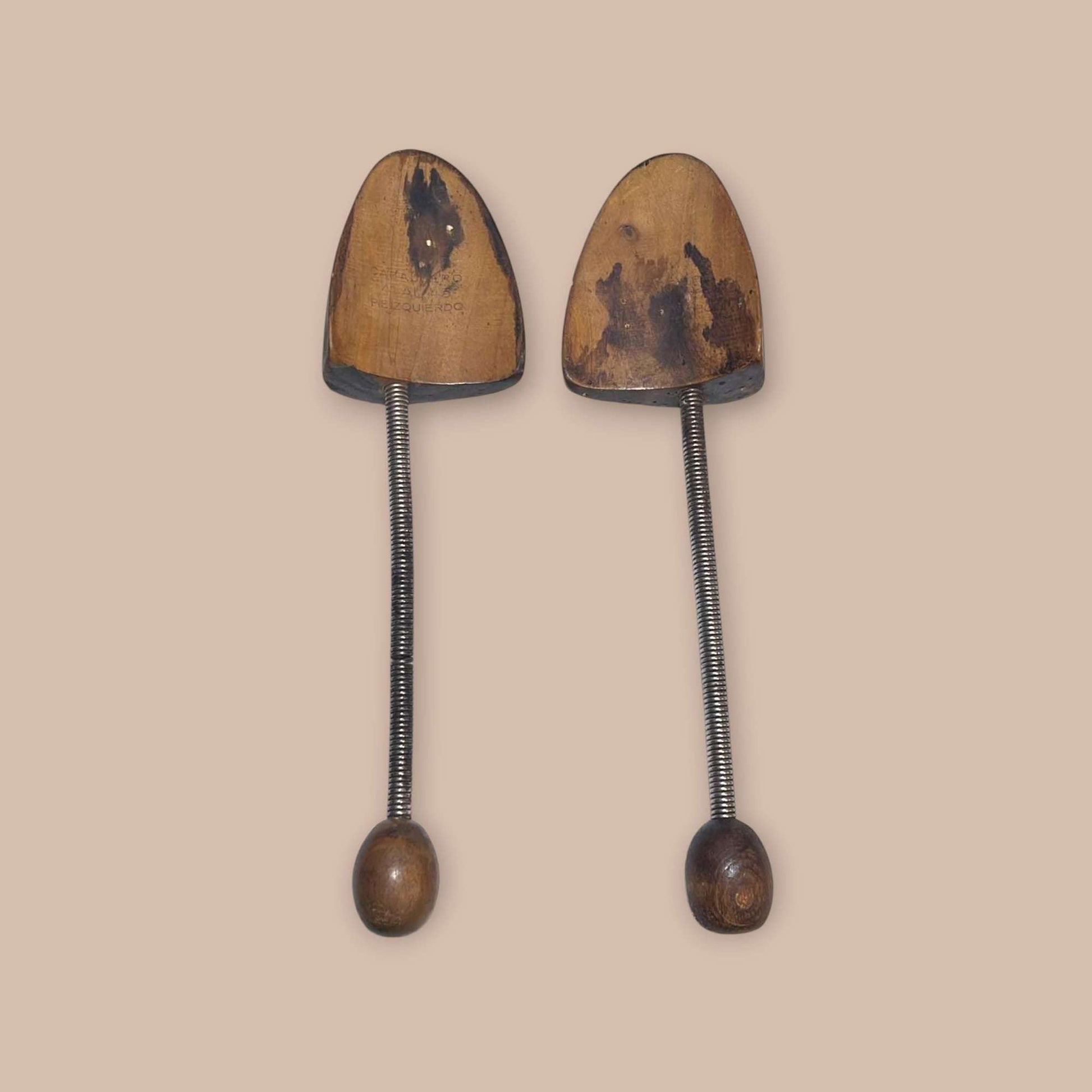 Par de hormas antiguas para zapatos, madera envejecida y resorte metálico.