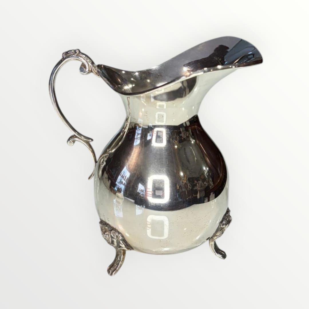 Jarra de metal plateado con diseño clásico y patas ornamentadas, ideal para decoración elegante en el hogar. Elegancia clásica y diseño intemporal.