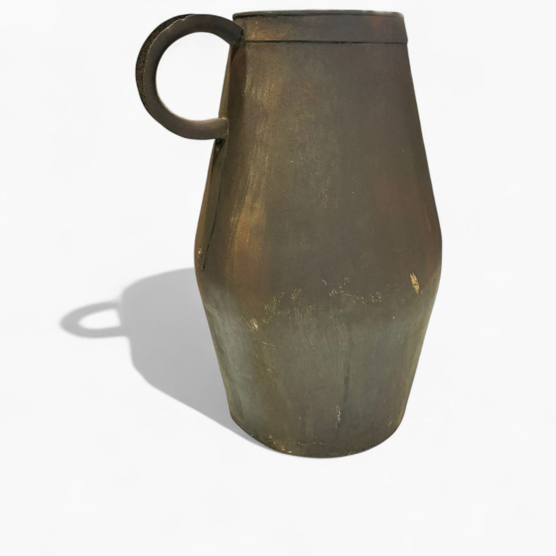 Con unas medidas de 25 × 16,5 × H40 cm, esta jarra destaca por su diseño vertical, su cuerpo sólido y su asa forjada manualmente fijada con remaches visibles, un detalle técnico que confirma su elaboración artesanal. 