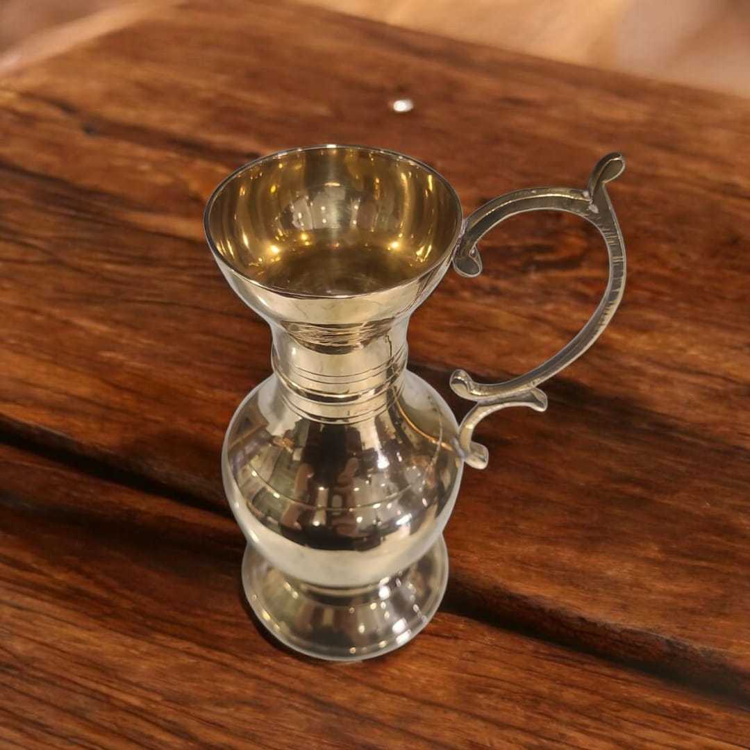 Vista superior de jarra dorada vintage con diseño curvo y asa decorativa. Perfecta para ambientaciones elegantes o colección decorativa.