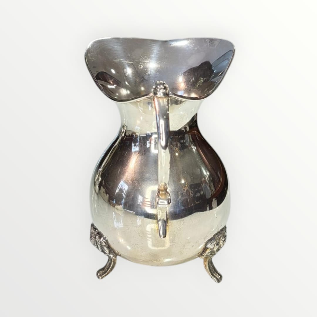 Jarra de metal plateado con diseño clásico y patas ornamentadas, ideal para decoración elegante en el hogar. Elegancia clásica y diseño intemporal.