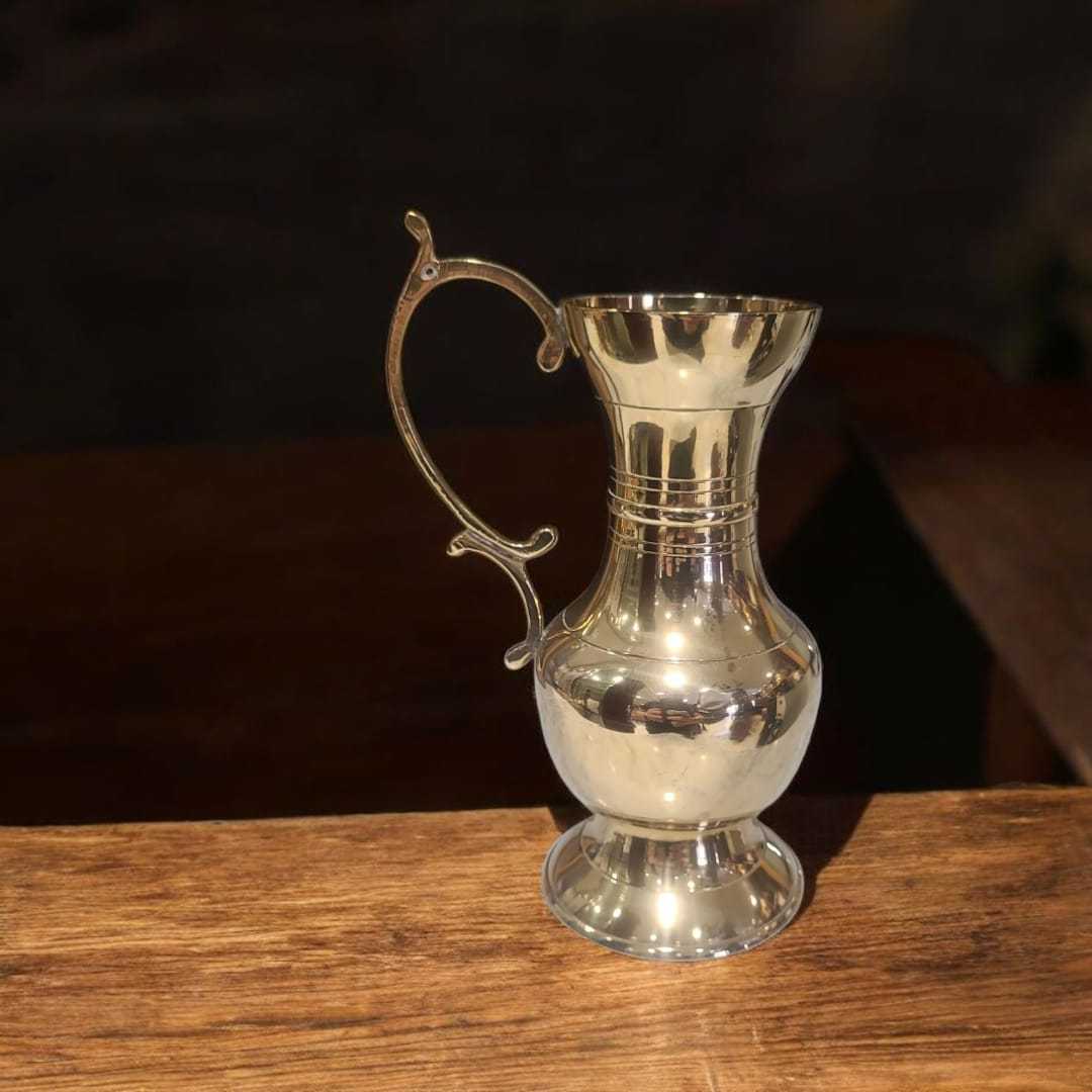 Vista superior de jarra dorada vintage con diseño curvo y asa decorativa. Perfecta para ambientaciones elegantes o colección decorativa.