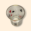 Vaso visto desde arriba con símbolos de baraja francesa y borde dorado, perteneciente al juego de jarra y vasos vintage de cristal.