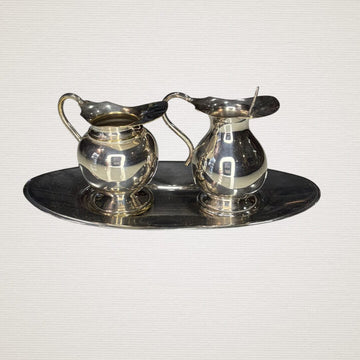 Pareja de jarritas vintage de metal plateado con bandeja