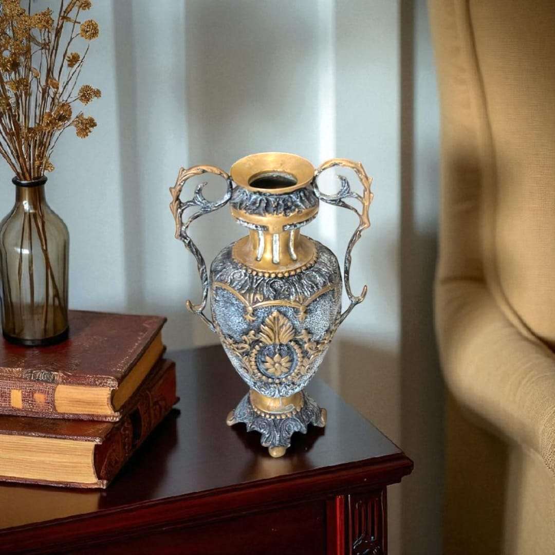 Detalle frontal del jarrón de bronce con relieves florales dorados.