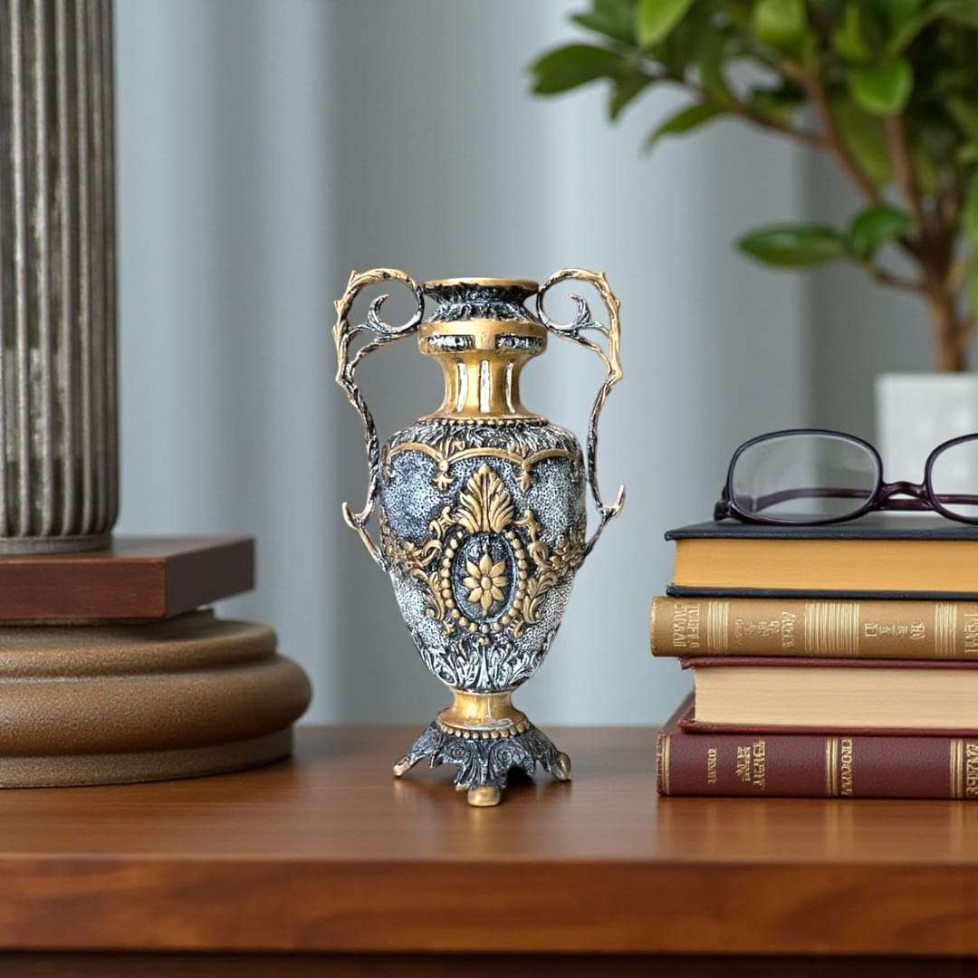 Jarrón de bronce clásico en ambiente elegante junto a libros antiguos.