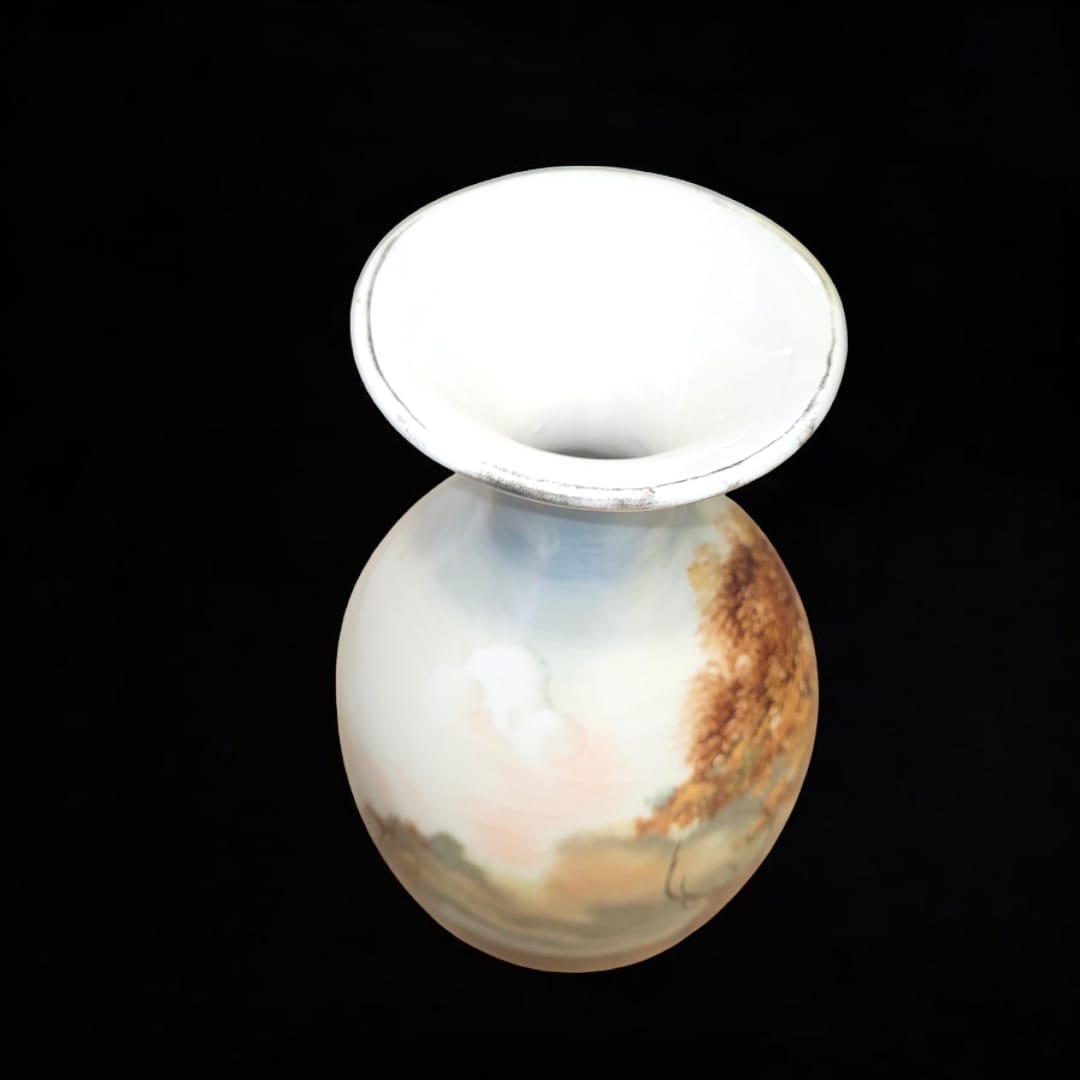 Vista superior de jarrón de porcelana decorado con paisaje natural y filo dorado, ideal para decoración elegante.