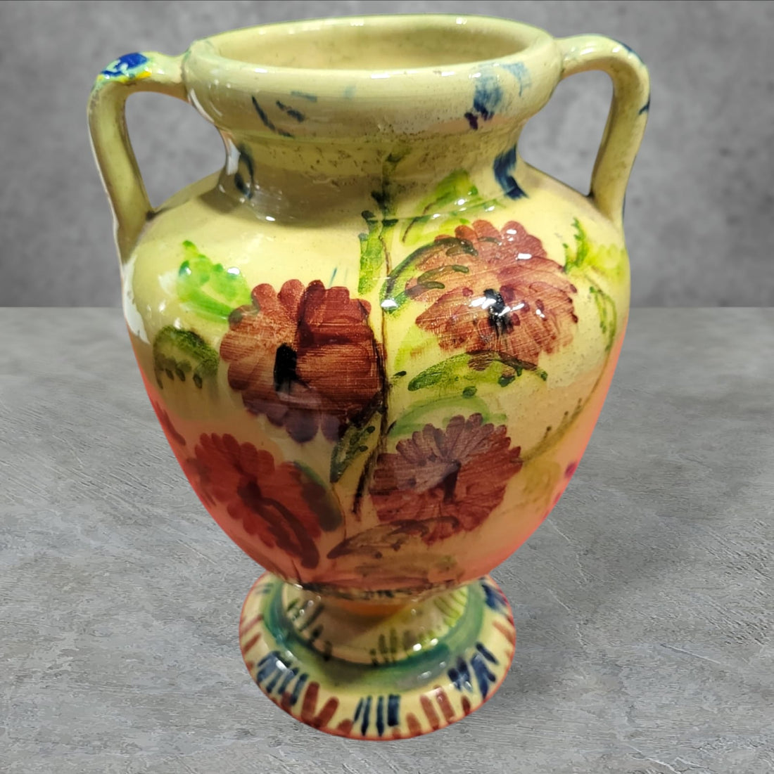 Ánfora de cerámica esmaltada pintada a mano con diseño floral en tonos cálidos. Elegante pieza artesanal ideal para la decoración del hogar.