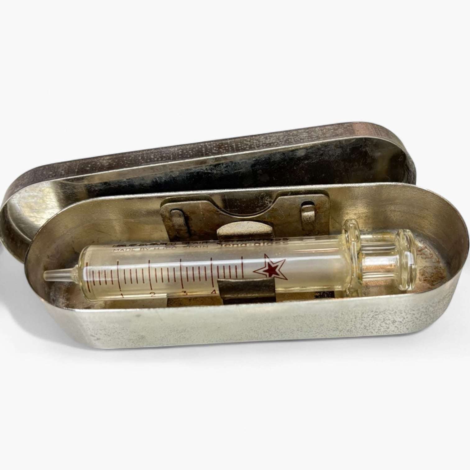 Estuche metálico cerrado de la jeringa antigua de cristal.