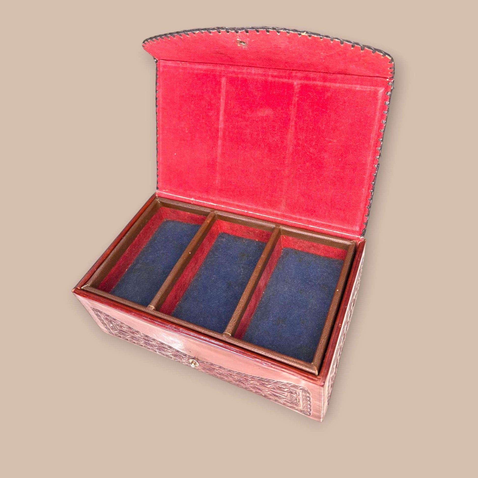 Joyero de cuero con relieves tipo calendario azteca, interior forrado en terciopelo azul con divisiones de madera. Ideal para decoración artesanal.