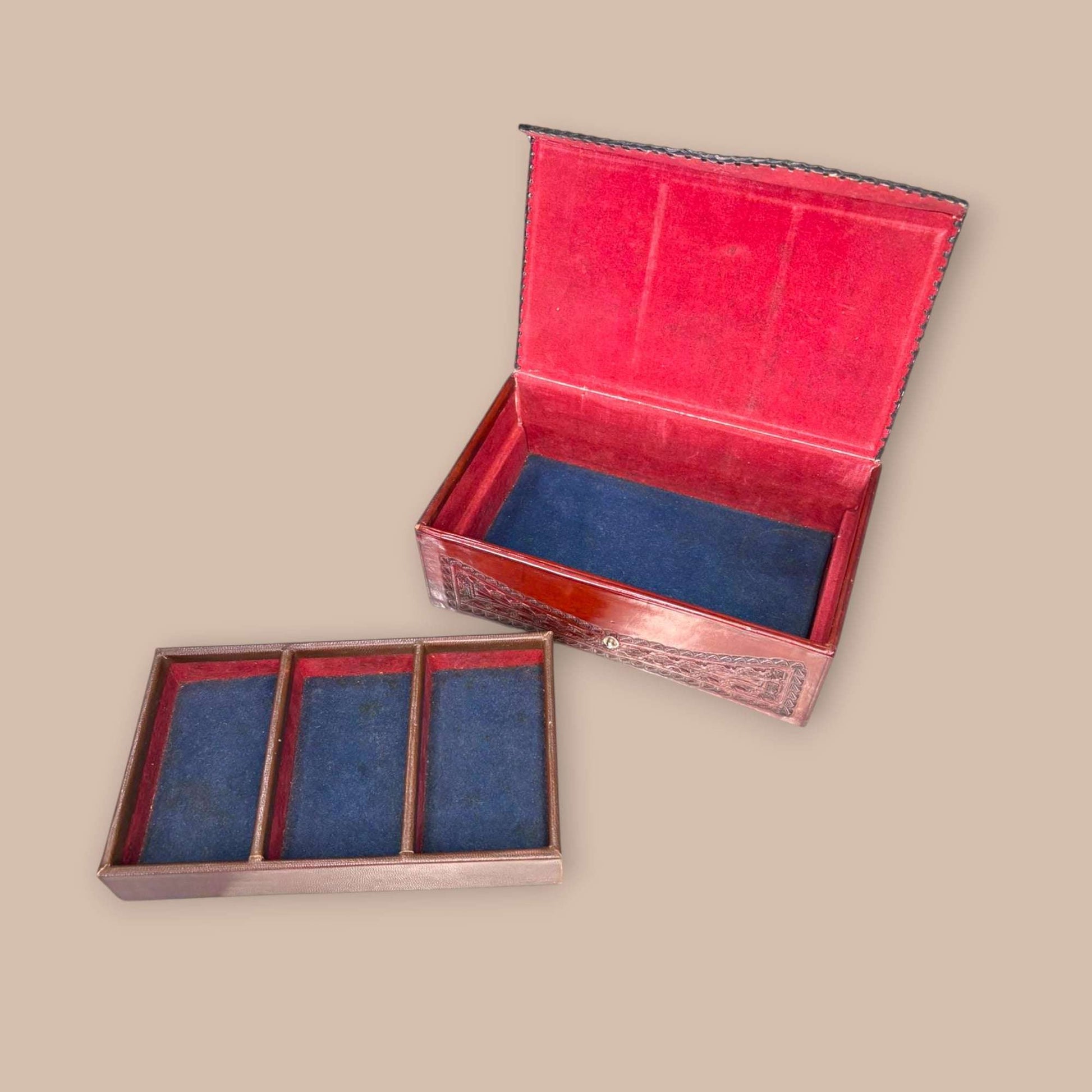 Joyero de cuero con relieves tipo calendario azteca abierto, interior forrado en terciopelo azul y compartimentos extraíbles. Ideal para decoración y colección.