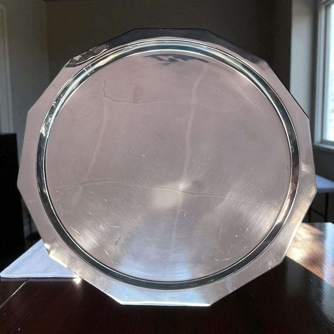 Detalle de la cafetera de metal plateado con acabado brillante.