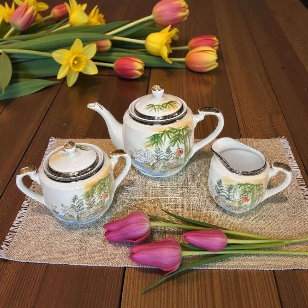 Set completo de juego de café japonés de porcelana con tazas, platos y tetera en mesa de jardín. Detalles orientales pintados a mano.