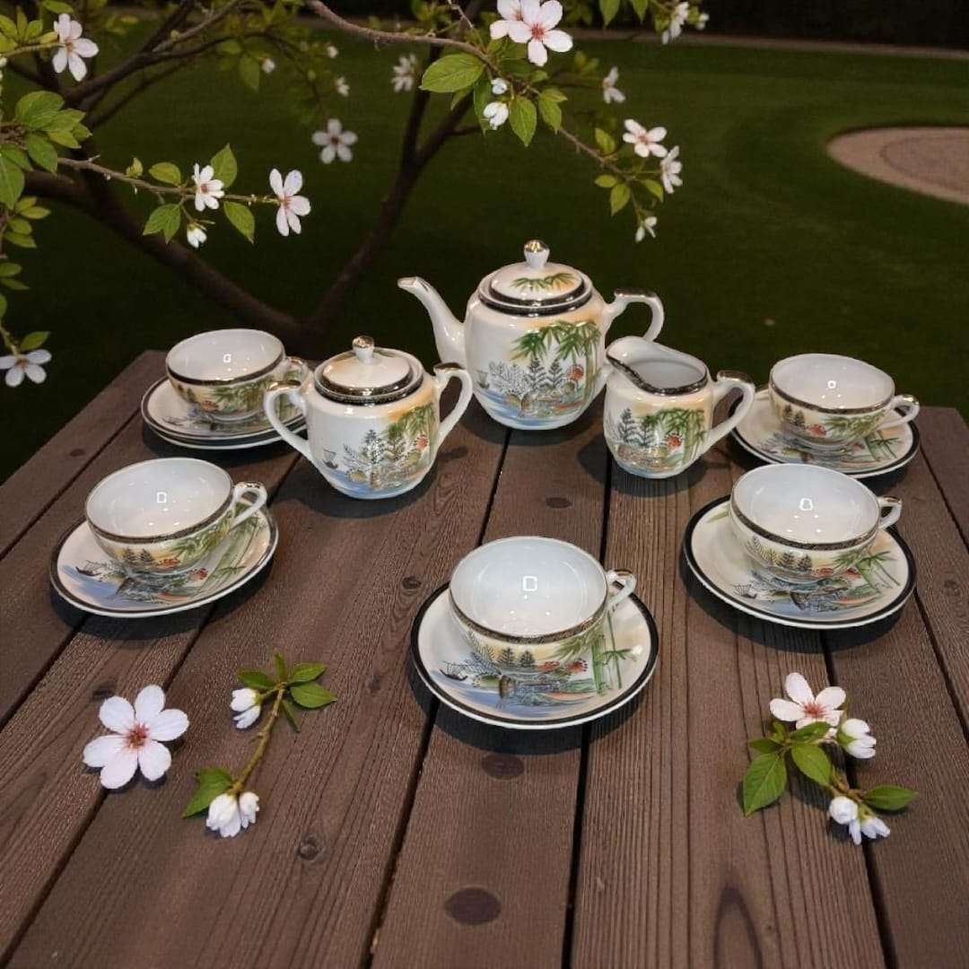 Set completo de juego de café japonés de porcelana con tazas, platos y tetera en mesa de jardín. Detalles orientales pintados a mano.