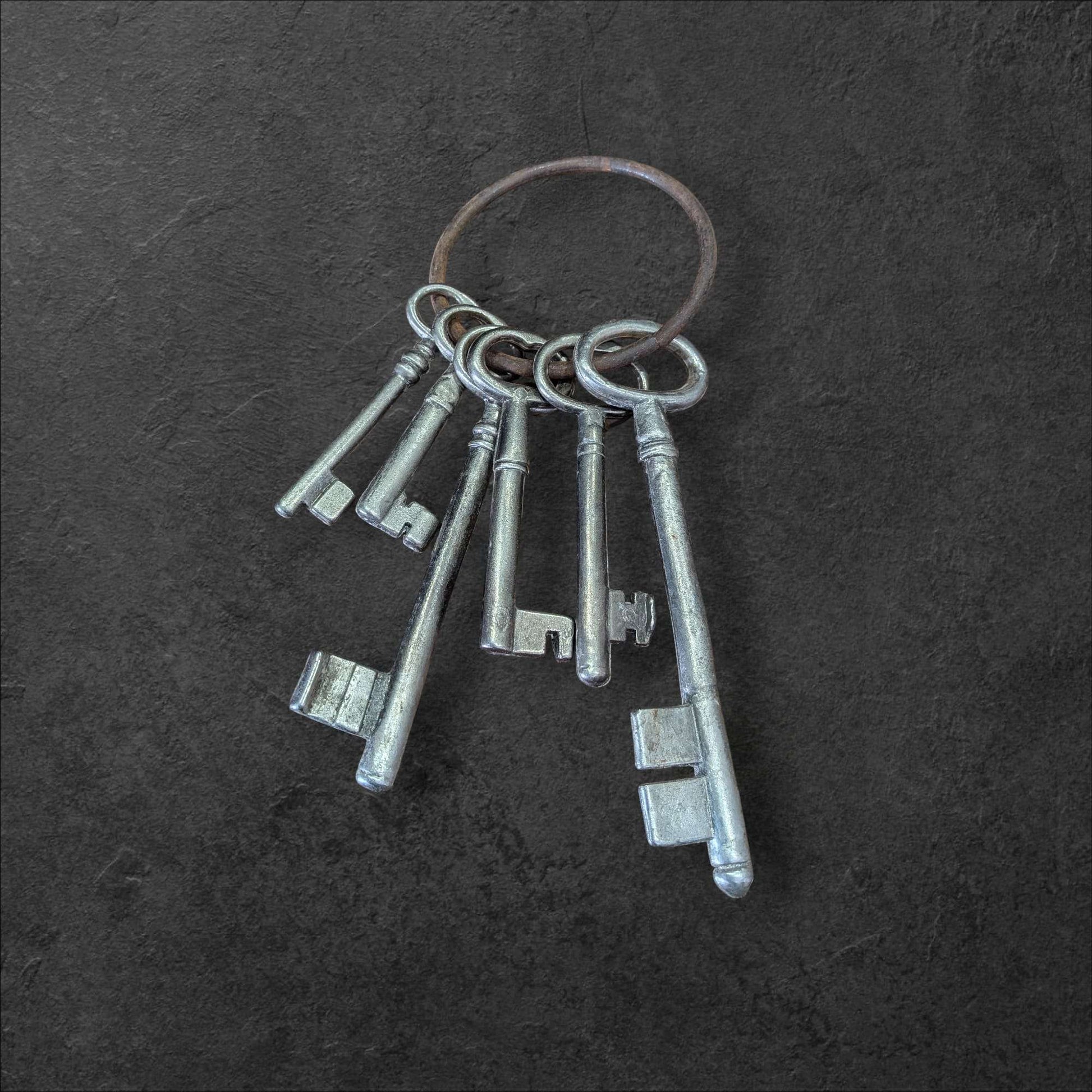 Llaves de la Suerte: un símbolo que atrae lo bueno, juego decorativo de llaves antiguas en anillo metálico sobre fondo oscuro. Ideal para decoración vintage con estilo histórico.