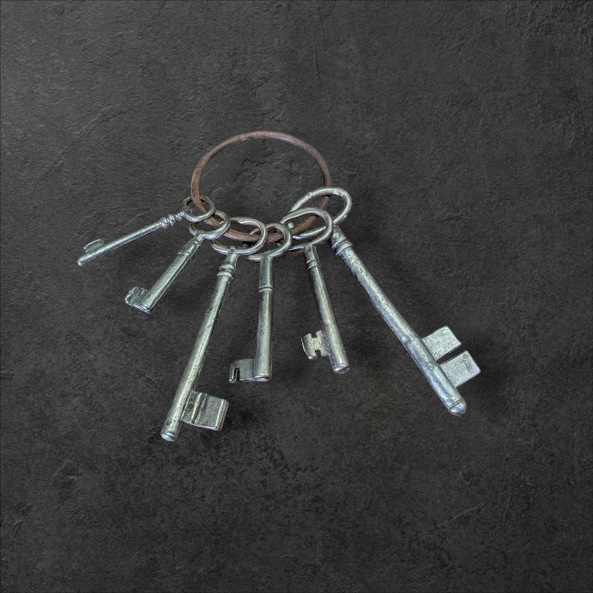 Llaves de la Suerte: un símbolo que atrae lo bueno, juego decorativo de llaves antiguas en anillo metálico sobre fondo oscuro. Ideal para decoración vintage con estilo histórico.