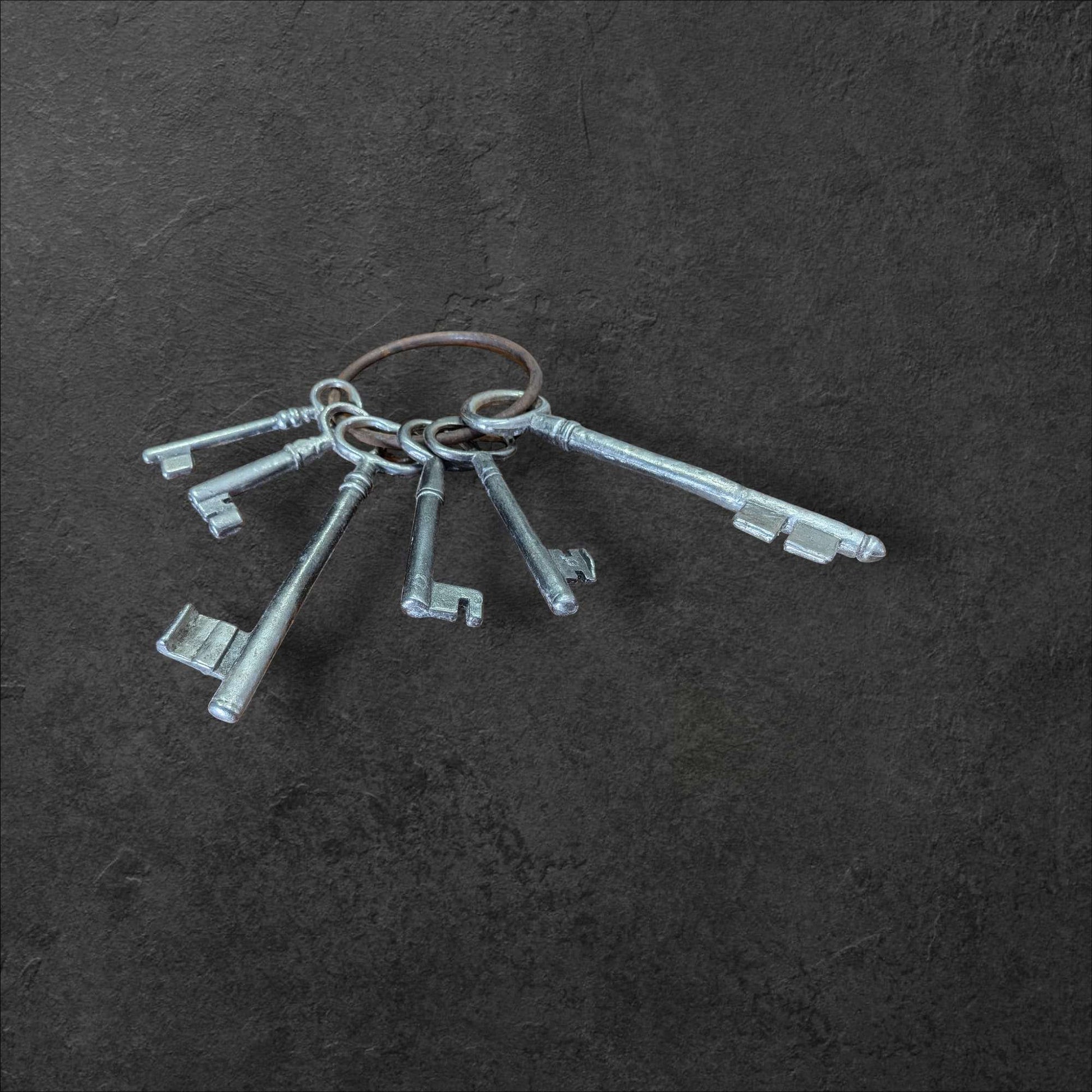 Llaves de la Suerte: un símbolo que atrae lo bueno, juego de llaves decorativas vintage en anillo metálico sobre fondo oscuro. Ideal para decoración histórica en el hogar.