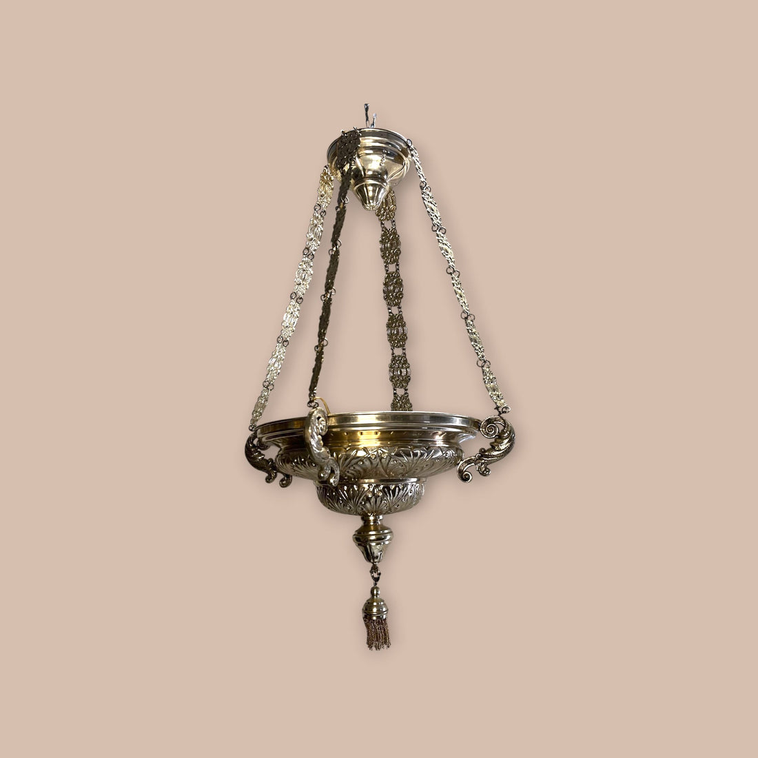 Lámpara votiva de metal plateado colgante con cadenas ornamentales.