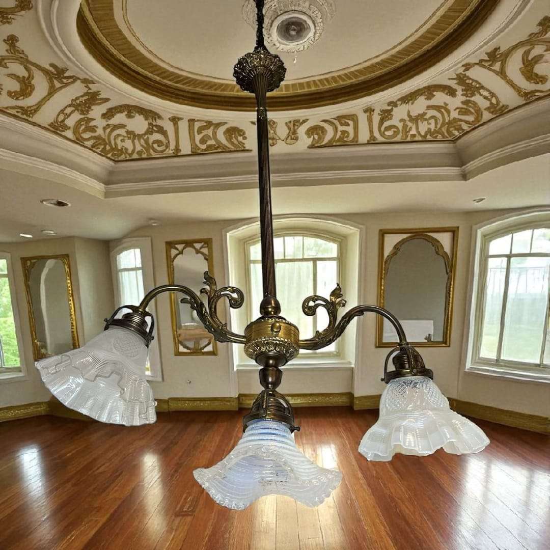 Lámpara de techo de metal con tres brazos en salón clásico.