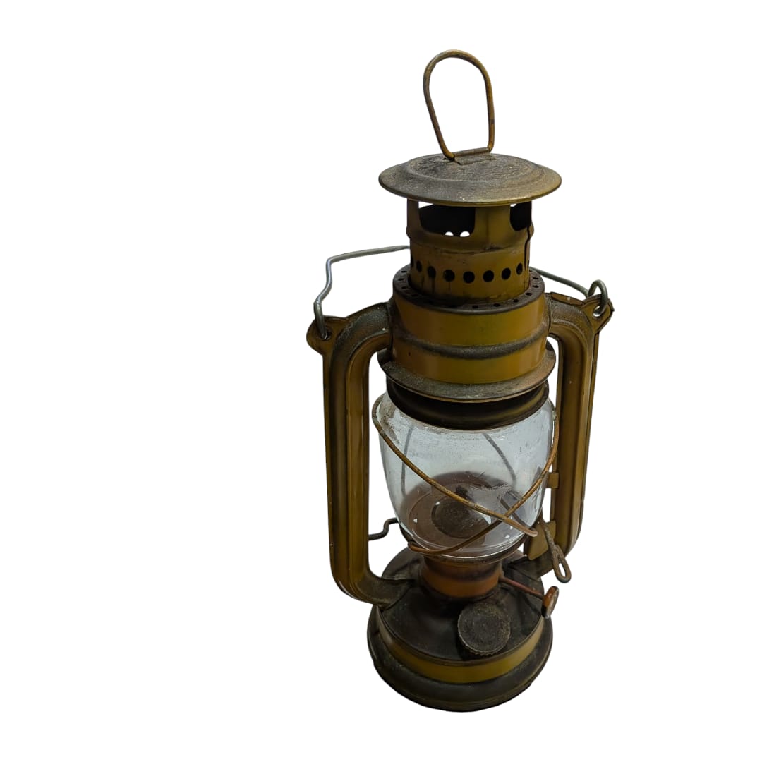 Lámpara rústica de petróleo de latón y vidrio soplado en primer plano.