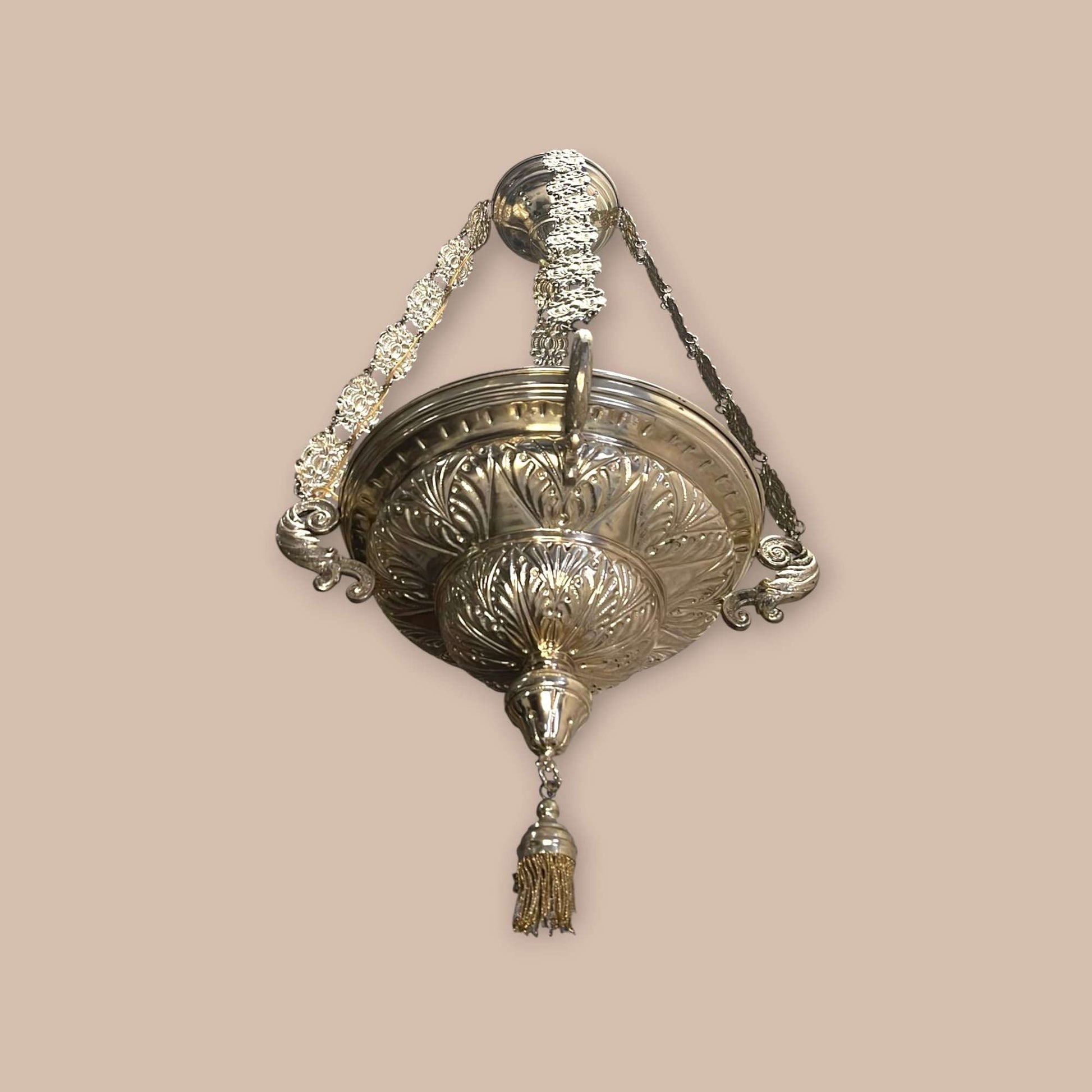 Lámpara votiva sacra colgada mostrando sus cadenas repujadas.