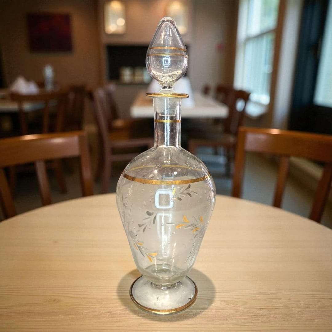 Este elegante conjunto está compuesto por una Licorera y tres copas a juego, todas elaboradas en cristal fino y decoradas con delicados motivos en dorado. 