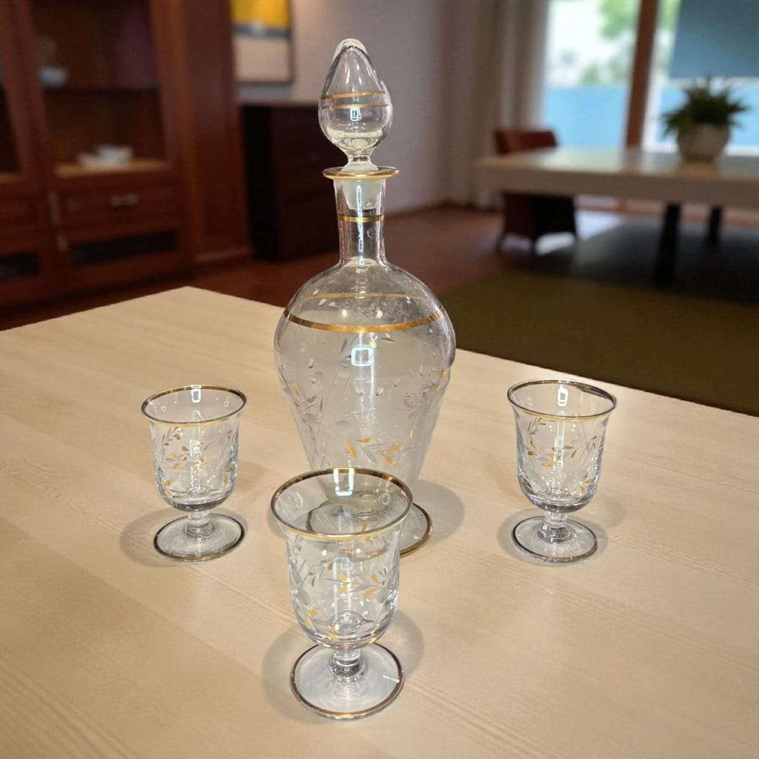 Este elegante conjunto está compuesto por una Licorera y tres copas a juego, todas elaboradas en cristal fino y decoradas con delicados motivos en dorado. 
