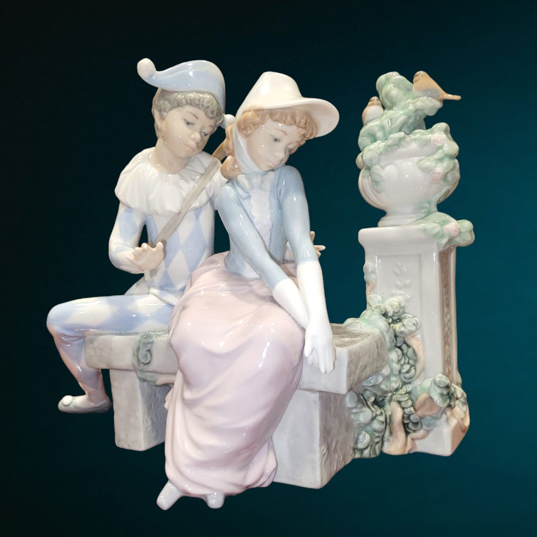 Figura de porcelana NAO LLADRÓ 'Amor precioso' con pareja romántica en banco, detalles refinados y acabado elegante. Ideal para decoración y coleccionistas.